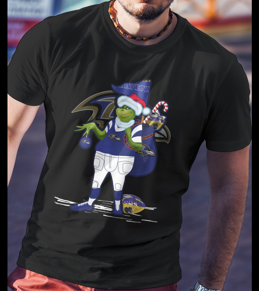 Grinch Santa Holding Candy Cane Bag And Baltimore Ravens Football In Ravens T-Shirt