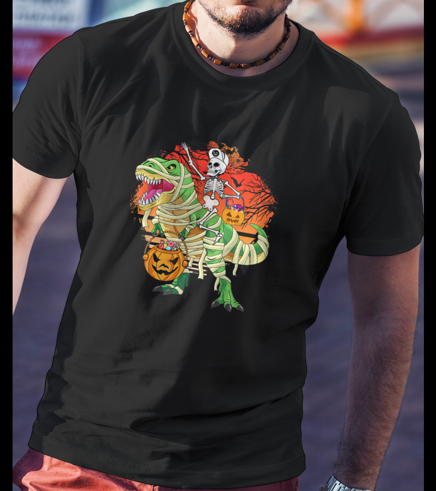 Skeleton Riding Mummy Dinosaur Rex With Halloween Pumpkins On Spooky Background T-Shirt