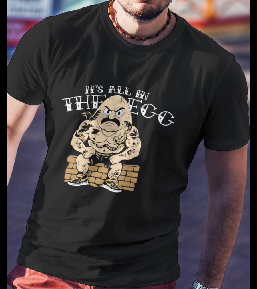 It's All In The Egg Muscular Cartoon Character With Mustache Sitting On Brick Wall T-Shirt