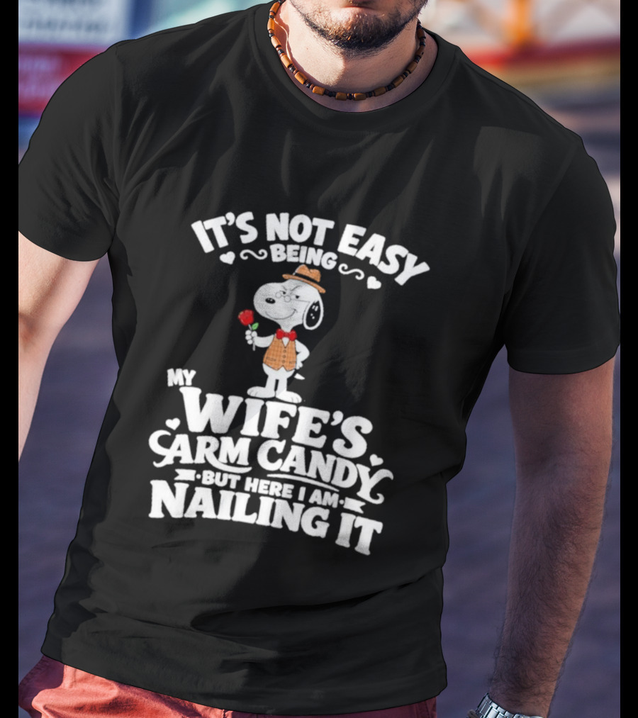 Snoopy It's Not Easy Being My Wife's Arm Candy But Here I Am Nailing It T-Shirt