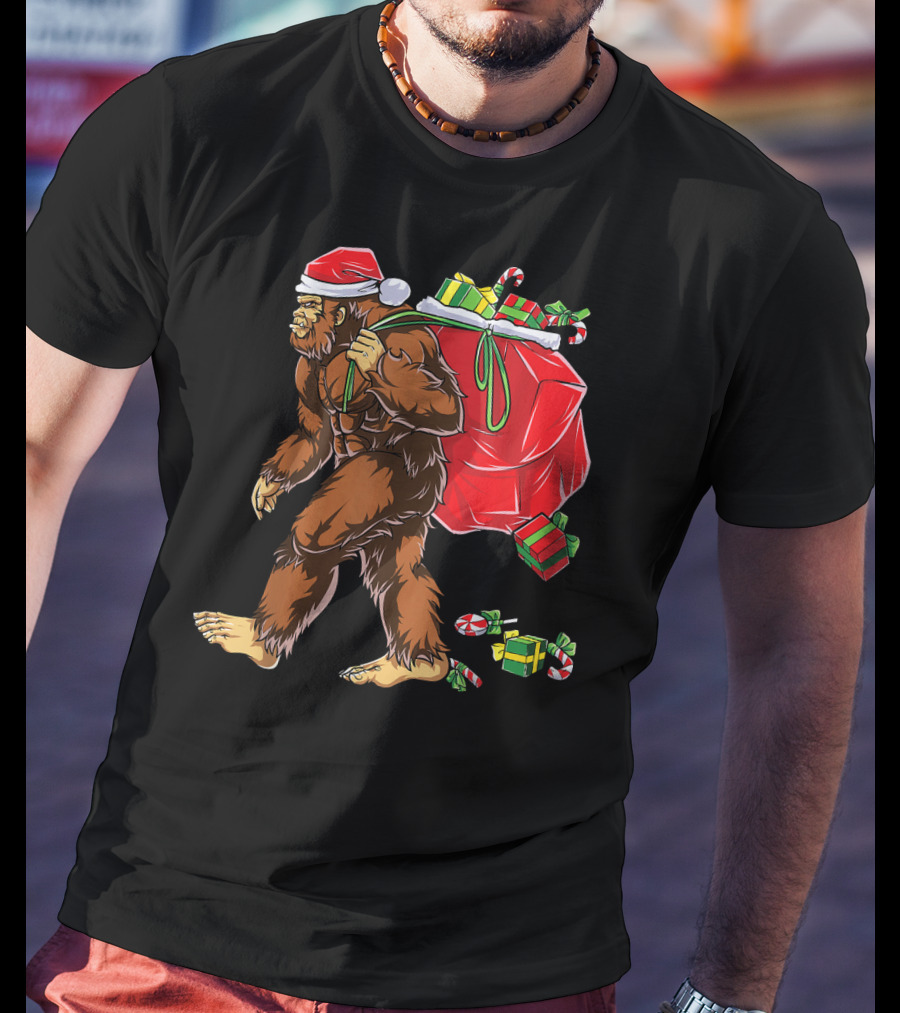 Bigfoot Santa Hat Carrying Christmas Presents And Candy Canes T-Shirt