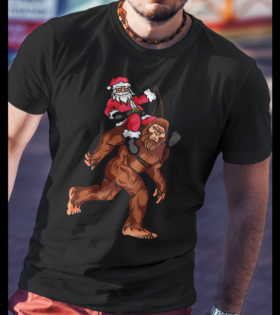 Bigfoot Carrying Santa Claus In Christmas T-Shirt